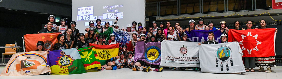 Indigenous Rising and Team Czech Republic take a group photo with their national/tribal flags after a game at the Roller Derby World Cup in July 2025.